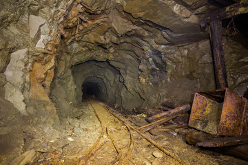 Underground mine shaft gold copper ore tunnel gallery with rails and miners stuff