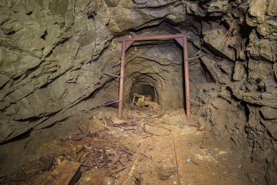 Underground mine shaft gold copper ore tunnel gallery with rails and miners stuff