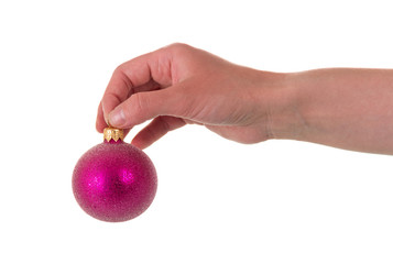 Female hand holds pink New Year's toy-ball, isolated on white background