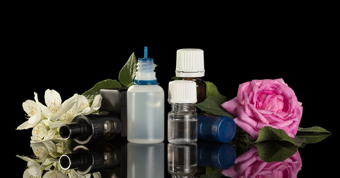 Electronic cigarette and a set of liquids for smoking with floral scent isolated on black background