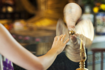 Worshipper at Che Kung Temple, Tai Wai, spinning a brass wheel of fortune