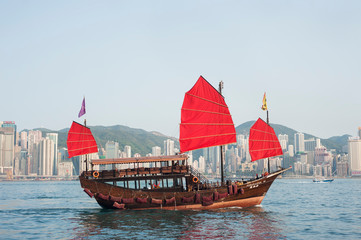 Naklejka premium A tourist tour junk crosses Victoria Harbour, Hong Kong