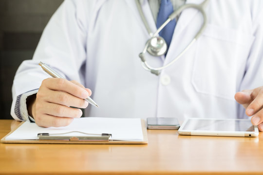 Professional doctor writing note for medical records about new patient