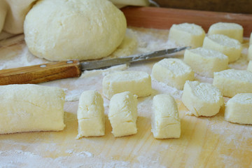 Making traditional russian or ukrainian cottage cheese lazy dumplings on wooden background. Italian gnocchi