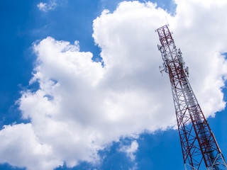Telecommunication equipment on the steel structure tower and the white clouds in blue sky