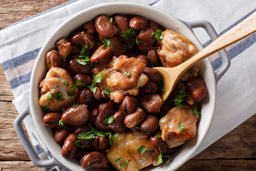 Slow cooked chicken with broad beans close up in a bowl. horizontal top view