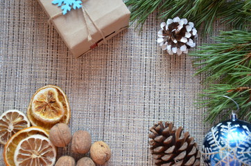 Christmas composition. Christmas gift, knitted blanket, pine cones, fir branches on wooden white background. Flat lay, top view snowflakes christmas treats christmas decorations
