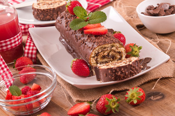 Chocolate roll with hazelnuts and strawberries. 