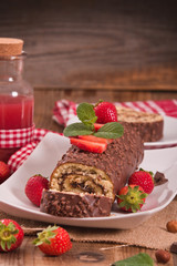 Chocolate roll with hazelnuts and strawberries. 