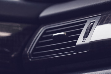 car air conditioning vents and louvers with open and close dial, modern car interior detail, shallow depth of field, filter effect