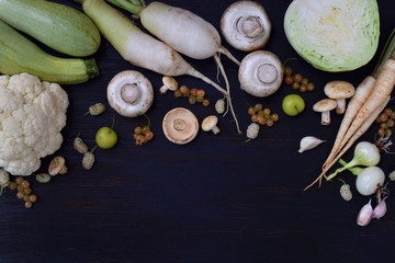 White vegetables and fruits on a wooden background. Flat lay. Currant, cauliflower, champignons, radish, parsley, mushrooms garlic Onion cabbage mulberry