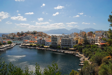 Fototapeta premium View of colorful houses in Agios Nikolaos, Crete, Greece, and mountain range