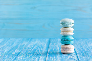 Delicious Macaroons on a blue wooden table closeup