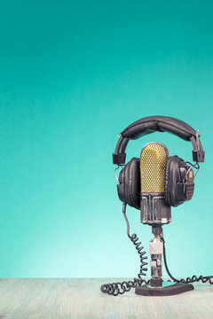 Retro studio ribbon microphone and headphones on table front gradient mint green wall background. Vintage old style filtered photo