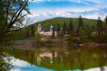 Northern front of Lillafured palace in Miskolc, Hungary. Lake Hamori in foreground with reflections. Travel outdoor landmark background