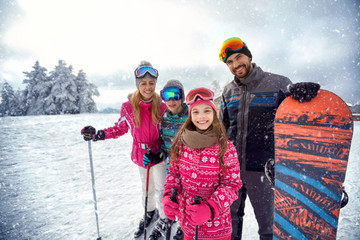 family enjoying winter sports and vacation on snow in mountains