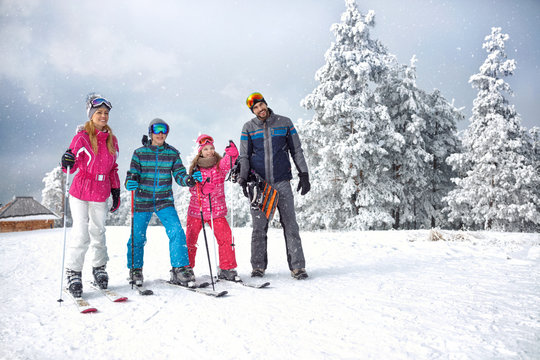 Skiing family enjoying winter vacation on snow in sunny cold day in mountains