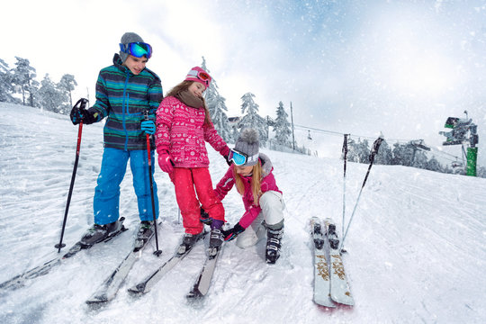 Skiing, winter fun-Mother preparing for skiing kids