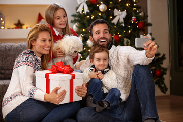 Obraz na płótnie Canvas Family making selfie with cell phone for Christmas