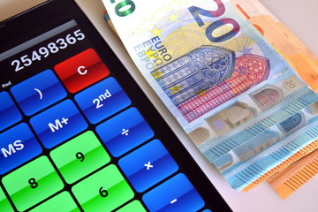 risparmiare, guadagnare e investire denaro un mucchietto di banconote in valuta euro e accanto una calcolatrice. close-up