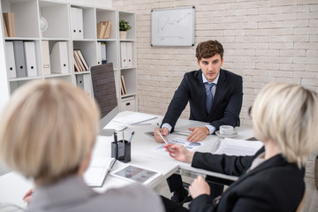 Portrait of handsome businessman heading financial meeting of executive board in conference room