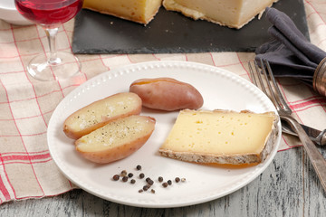 potatoes and french cheese tomme on white plate