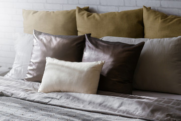 Bed maid-up with clean white pillows and bed sheets in beauty room. Close-up. Lens flair in sunlight.