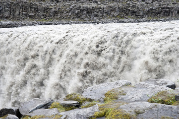 Falls in a typical Icelandic landscape, a wild nature of rocks and shrubs, rivers and lakes.