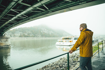 man standing under the bridge boat in the river