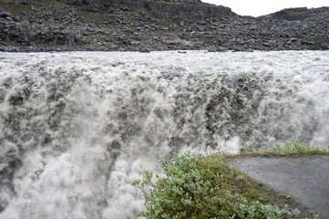 Falls in a typical Icelandic landscape, a wild nature of rocks and shrubs, rivers and lakes.