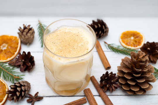 Homemade eggnog with cinnamon on wooden table. Flat lay
