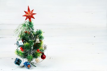 Christmas tree;  star, bauble, bell, red ribbons, gifts.