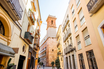 Fototapeta na wymiar Street view with beautiful old buildings and saint Bartolomeu tower in Valencia, Spain