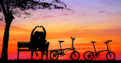 Plakat silhouette vintage bike and love couple in the holiday on sunrise time