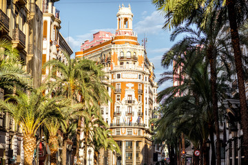 Street view with beautiful luxurious building and palm trees in Valencia city during the sunny day...