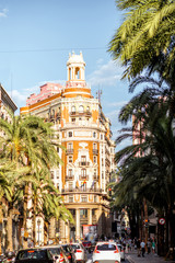 Street view with beautiful luxurious building and palm trees in Valencia city during the sunny day in Spain