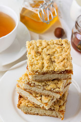 Sand cake with jam and nuts on the table.