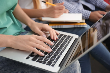 Fototapeta na wymiar Female student working on laptop, closeup