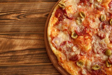 Half of pizza on wooden background