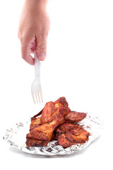Hand holding serving roasted chicken in aluminum foil with plastic fork. Food and appetizer...