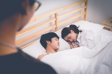 Husband looking at his wife lying with another man. Paramour and divorce concept. Social problem...