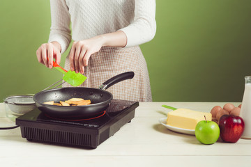 House wife wearing apron making. Steps of making cooking apple cake. Cutting green apple.