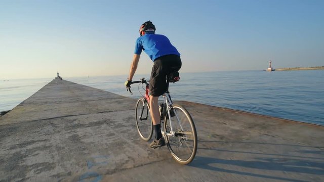 man riding bicycle on pier near the sea port