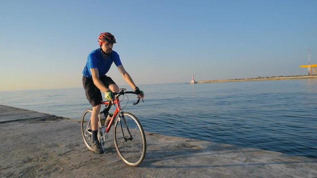 man riding bicycle on pier near the sea port