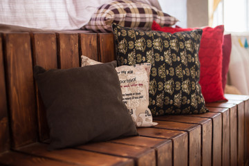 Colored pillows on wooden sofa