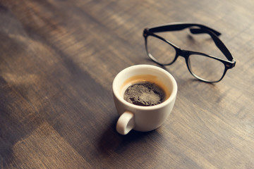 cup of coffee and glasses on table