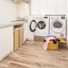 Laundry room with washer, dryer, basket and dirty clothes