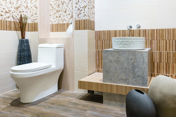 Modern spacious bathroom with bright tiles with toilet and sink. Side view