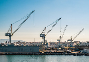 Fototapeta na wymiar cranes and shipyards in Livorno harbor. Tuscany, Italy.