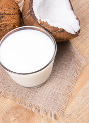 Coconut with coconut milk on wooden background.